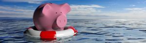 A piggybank on a life buoy out in open water.