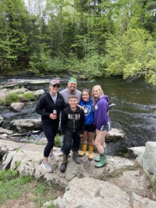 jeanette williams, a BSN graduate with her family by a river