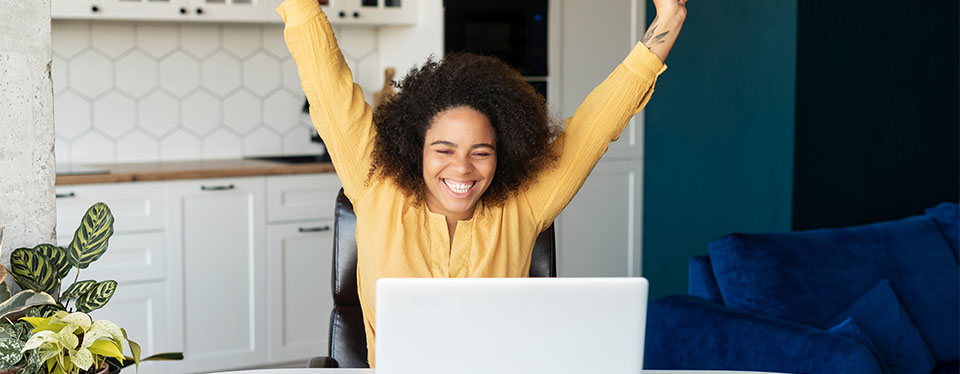 Woman celebratin in front of computer