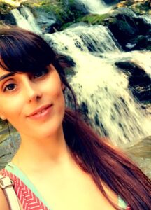 Travel nurse Erica Wildes posing next to a waterfall