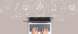 abstract image showing hands typing on laptop keyboard with graphic illustrations of a brain, learning, and education symbols in the background