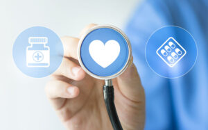 nurse holding a stethoscope up to a heart image