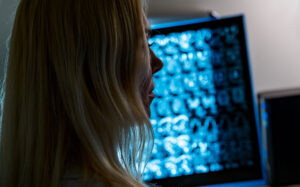 Female x-ray technician looking at imaging on a computer.