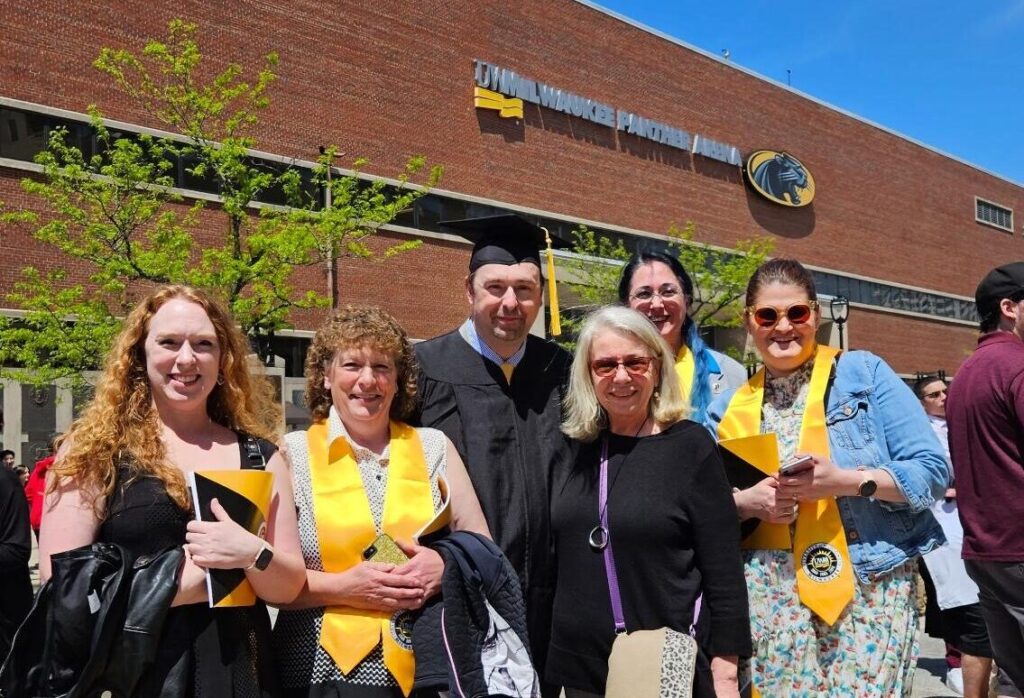 Torry standing with friends and family outside of the UW-Milwaukee Panther Arena following his commencement.