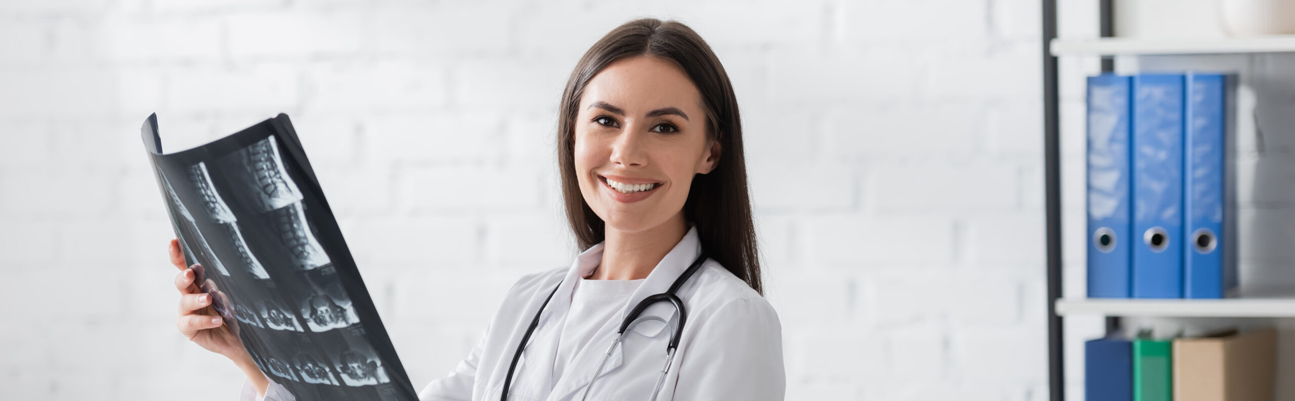 Positive Mri Positive doctor holding mri scan and looking at camera in clinic, banner