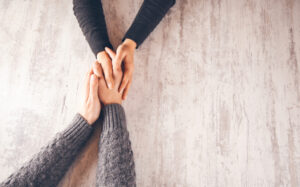 two individuals holding hands in a counseling session
