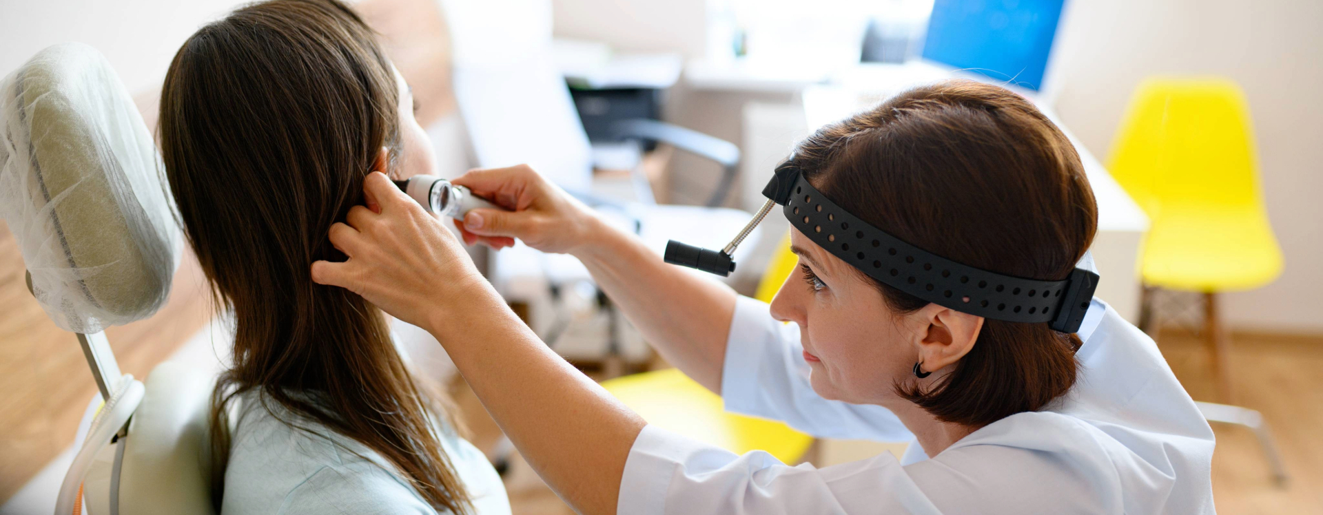 a nurse checks a patient's ear with an otoscope