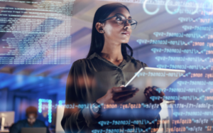 Photo of woman on tablet thinking of data analytics as software coding appears in the foreground