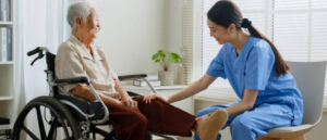 physical therapist helping an elderly man stretch his leg