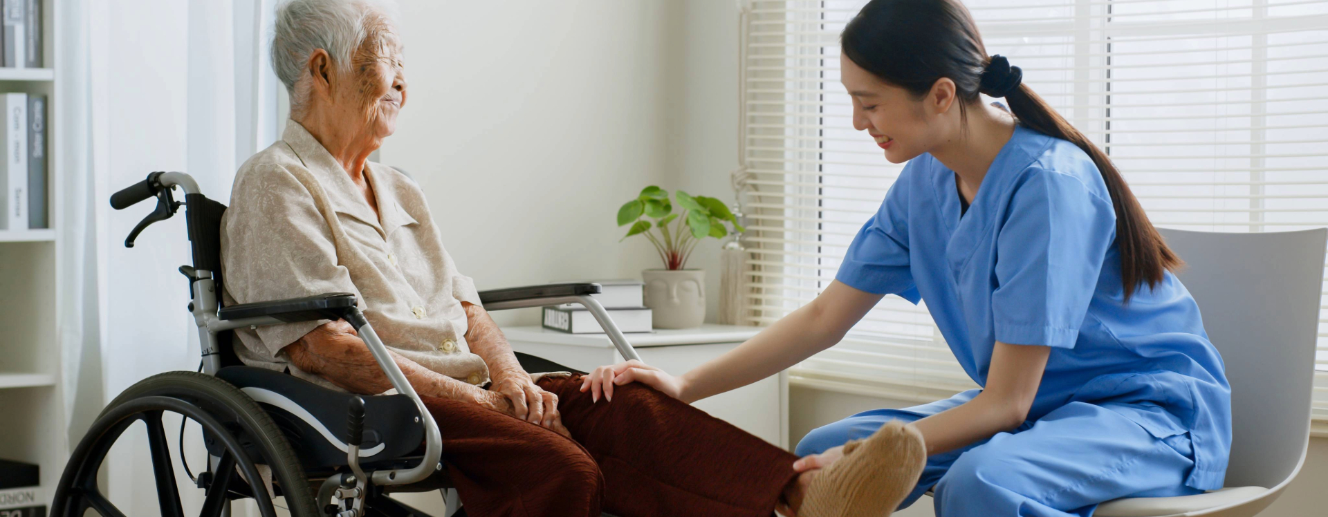 physical therapist stretches elderly man's leg
